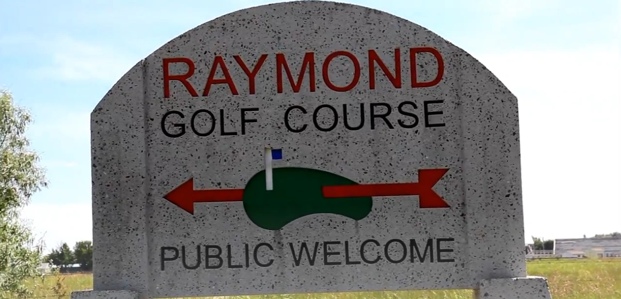 ntrance sign for Raymond Memorial Golf Course in Columbus, Ohio - 'PUBLIC WELCOME' text visible on weathered wooden marker with golf course landscape in background
